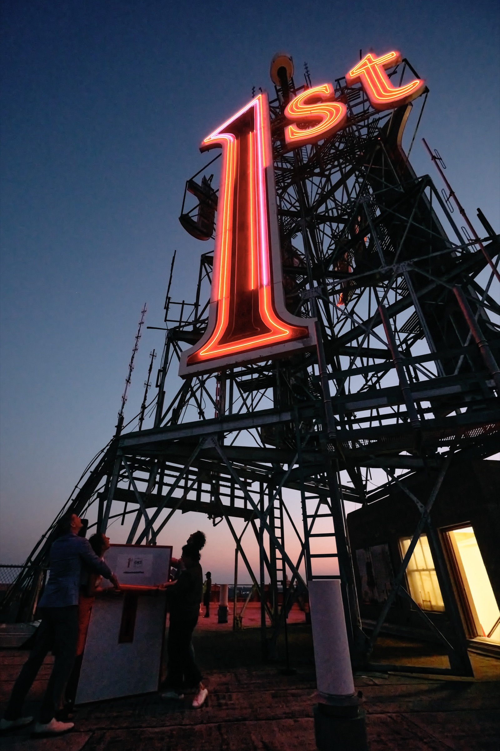 The relit 1st sign glowing red against the night sky