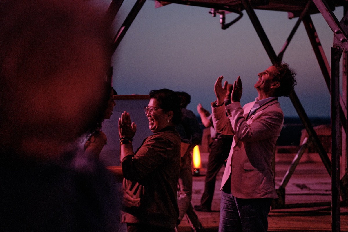 Guests on the rooftop applauding as the sign comes back to life